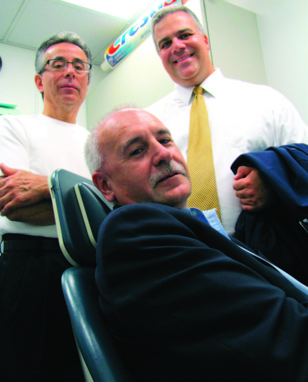 IN THE HOT SEAT: Johnston Mayor Joseph Polisena sits in one of two dental chairs inside the Ronald McDonald Care Mobile, also known as the Molar Express, as School Committee member Robert LaFazia and Assistant Superintendent of Schools Dr. Arthur Petrosonelli look on during last Thursday evening's preview tour. The Molar Express returns to Thornton School next week to provide free dental services to children ages 2 to 21.