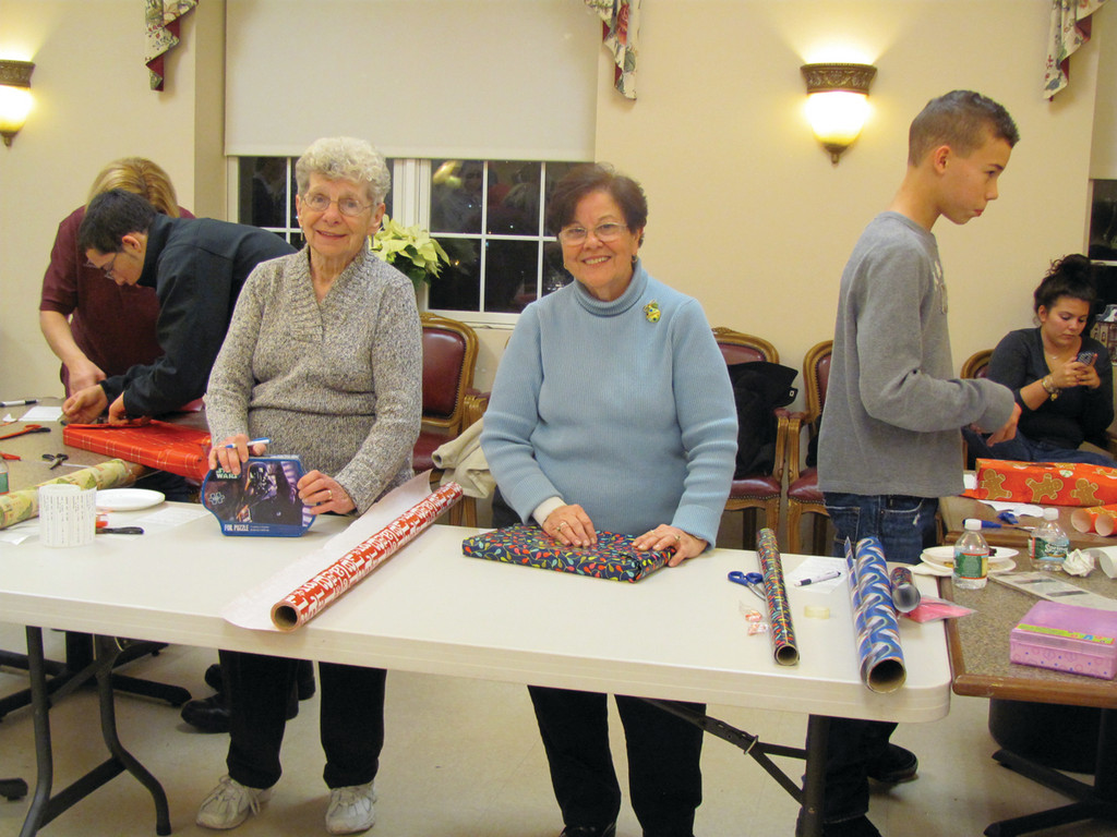 Claire Mathieu and Adeline Zany, who are volunteers at the Johnston Senior Center, wanted to help the Explorers Post 405 wrap presents last Thursday evening.