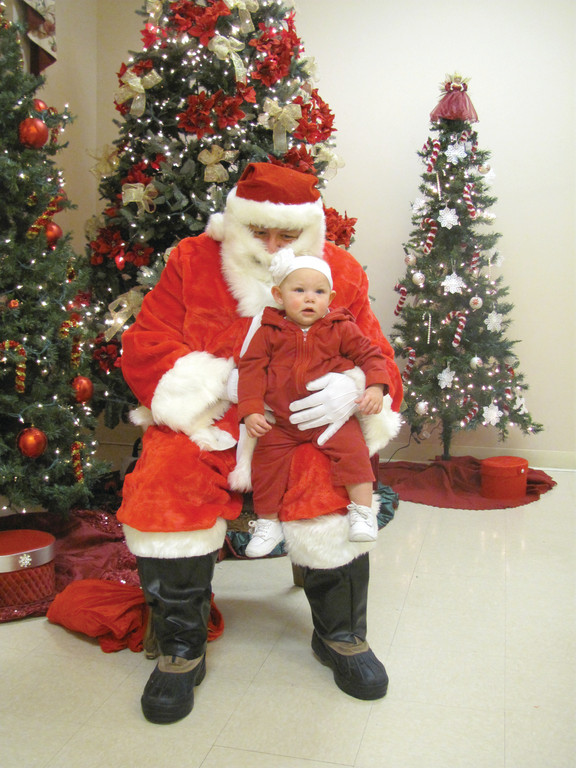 Santa Claus made the gift-wrapping party special for a host of people, including 8-month-old Natalie Carey, who he finally got to sit for a moment on his knee.