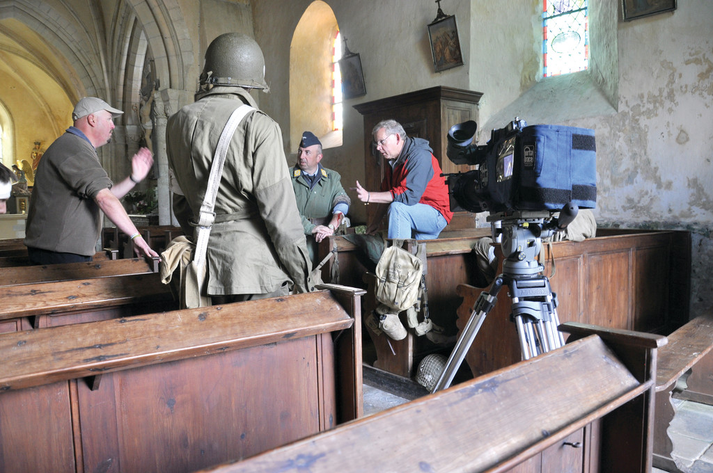 Filmmaker Jim Karpeichick consulted with historian and author Paul Woodadge (left) before filming for Eagles of Mercy in Angoville-au-Plain in Normandy. The church itself has stained glass windows honoring the two medics who saved lives on both sides of the battle for the village in WWII