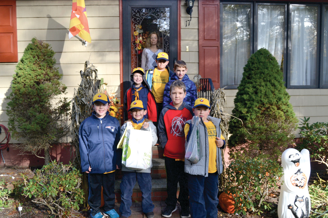 DONATIONS AND MORE: Cub Scouts pick up food donations from the Calestino residence. Along with providing bags of food donations, the Calestinos gave each of the scouts a full-sized candy bar left over from Halloween.