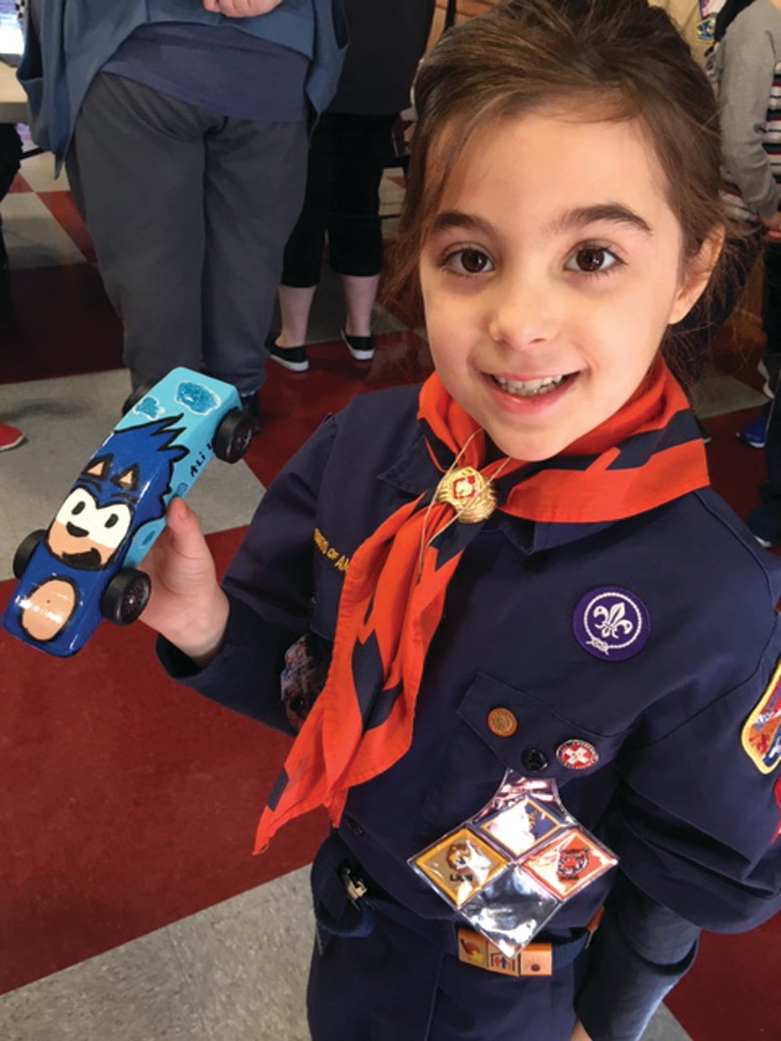 A PROUD PIONEER: Ali LaFazia, 7, shows off her award-winning car during last month’s Pinewood Derby Regionals. LaFazia is the first girl to ever compete at the tournament.