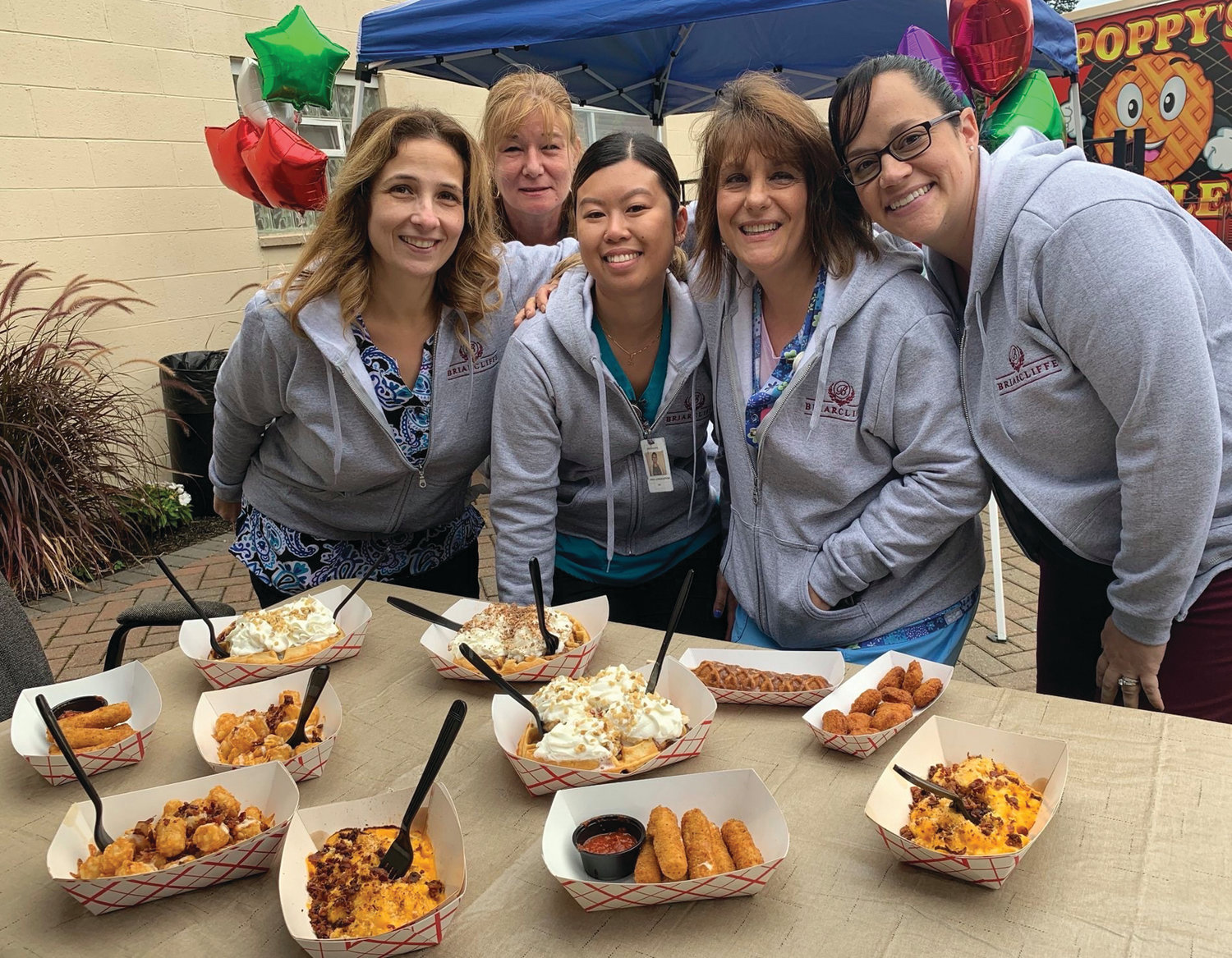 MOUTH-WATERING MUNCHIES: Briarcliffe nurses Jonna Matos, Lorna Parrillo, Linda Laungasoupom, Deborah Petronelli and Beth Brosnahan enjoy a lighter moment in front of the Poppy’s Waffle truck while waiting to sample the many unique foods that were featured during the recent Nurses Appreciation Day Luncheon.