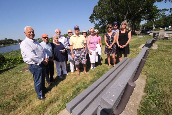 IN MEMORY OF BILL WALASKA: Members of the Warwick Neck Improvement Association gathered Wednesday at the Warwick Cove overlook on Warwick Neck Avenue to formalize an action that was delayed by the pandemic. Members watched as Rick Loring of AA Sign affixed a plaque to one of two benches the association installed at the overlook in recognition of all the late Senator William Walaska did for the neighborhood. Walaska died in 2017. Attending the occasion were Walaska’s daughters Leslie Baxter and Anne Marie DeMello