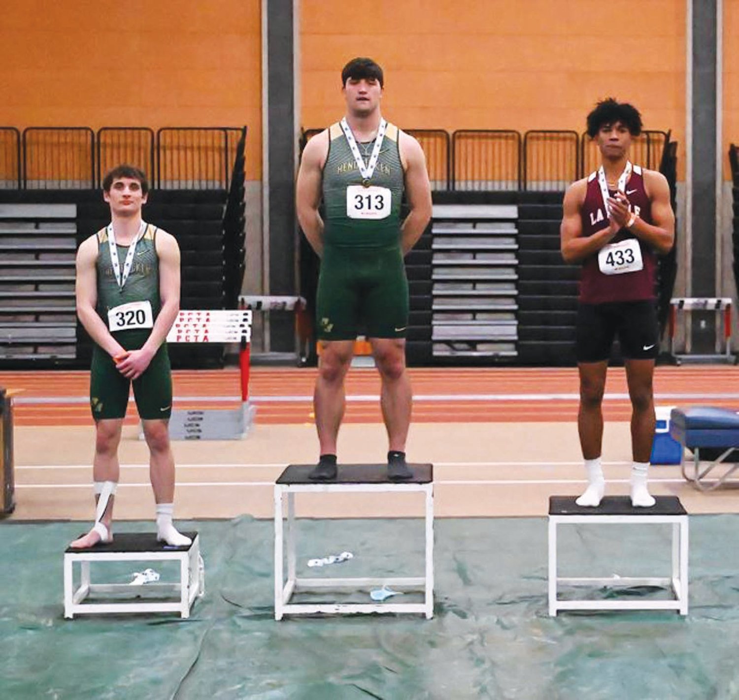 TOP OF THE PODIUM: Bishop Hendricken’s Brandyn Durand (center) after wiinning the 300 meter dash at last
week’s indoor track state championships in Providence.