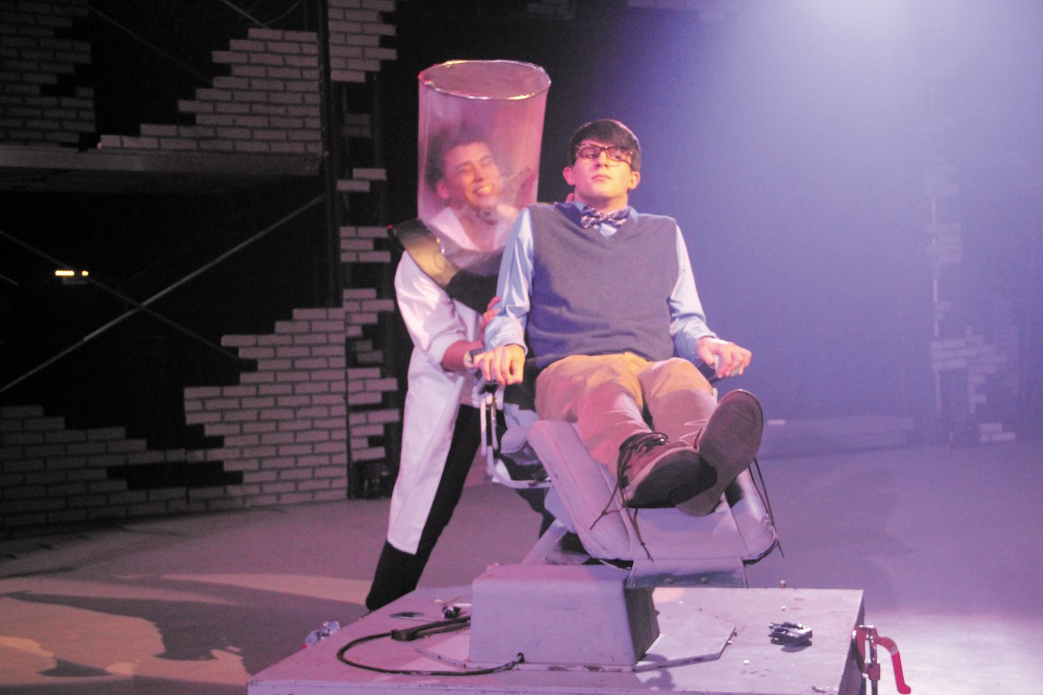 HORROR SHOW AT THE DENTIST: Jacob Rademacher
plays Seymour Krelborn as a patient in the dentist chair as
David Santana, playing Orin Scivello, D.D.S. in a hectic scene
in the Hendicken production of the Little Shop of Horrors
that opens tonight at 7 p.m. at the school.