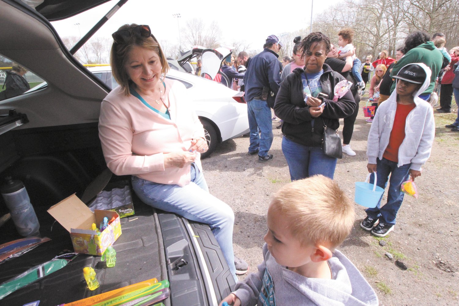 CASHING IN: Barbara Canton distributes prizes from the back of a SUV to those finding eggs with numbers from one to six. Kids claimed their prizes from vehicles with the corresponding number.  