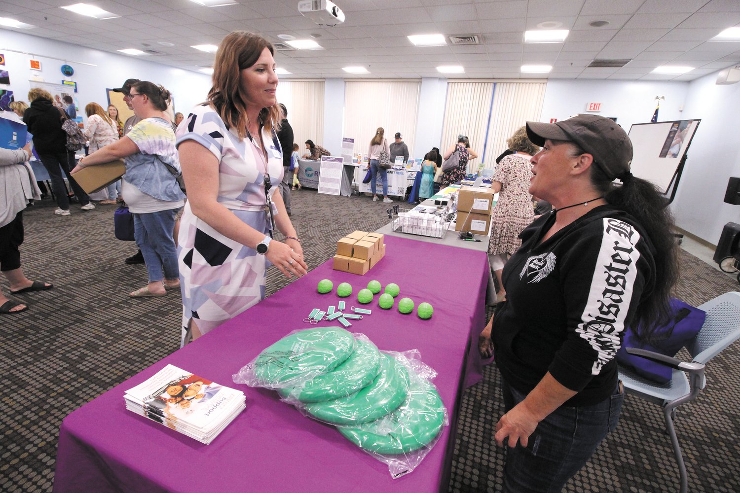 AT MENTAL HEALTH FAIR:  Cameron Kadek, left, and Martha Battella of the Parent Support Network compare notes at the mental health fair Kadek organized at the library. (Warwick Beacon photo)
