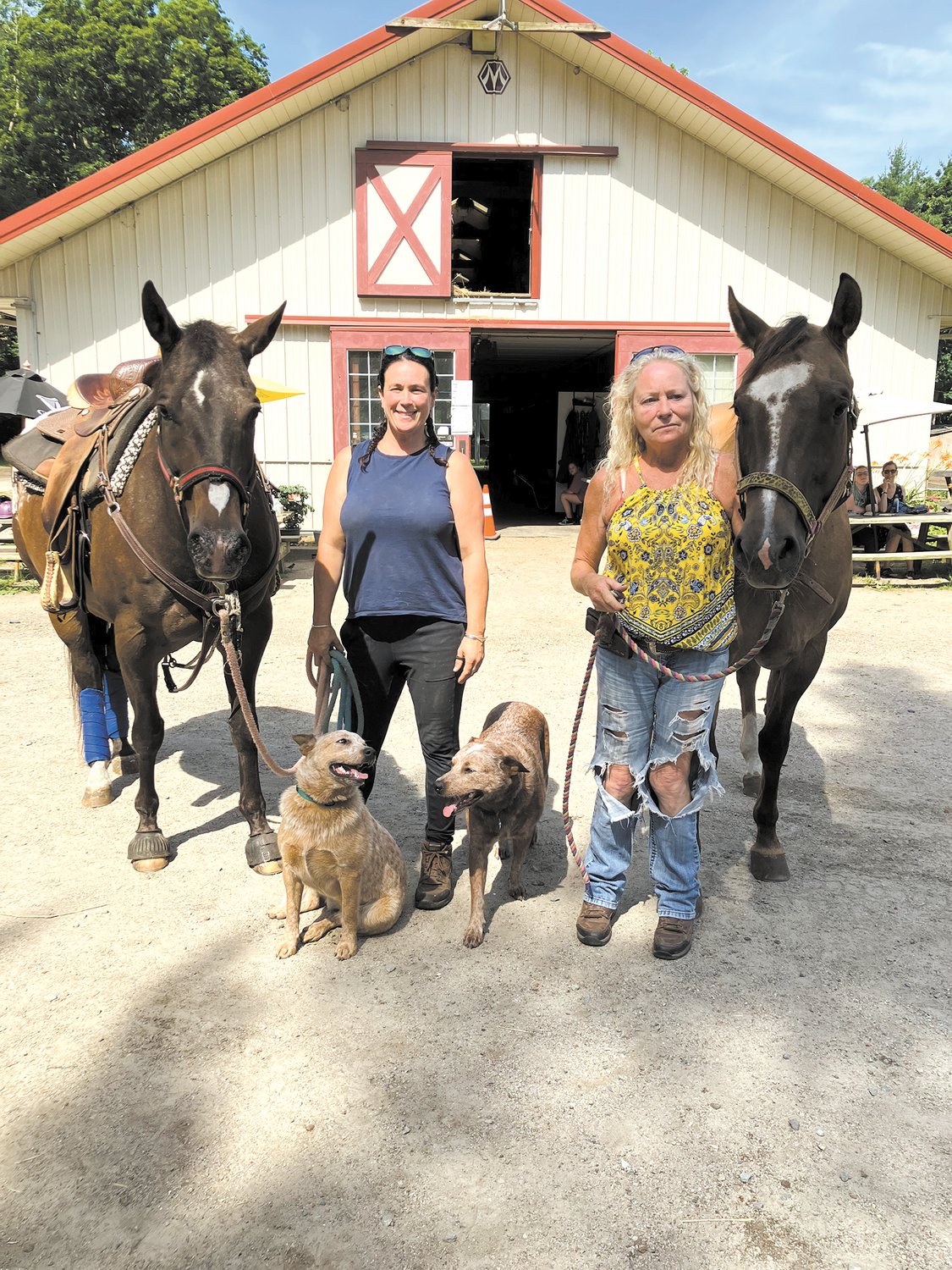 RUNNING THE BUSINESS: Pictured at the Goddard Park stable is Danielle, at left with her horse “Rita” and Lee with her horse “Sista.” The two dogs are Babe and Blue.