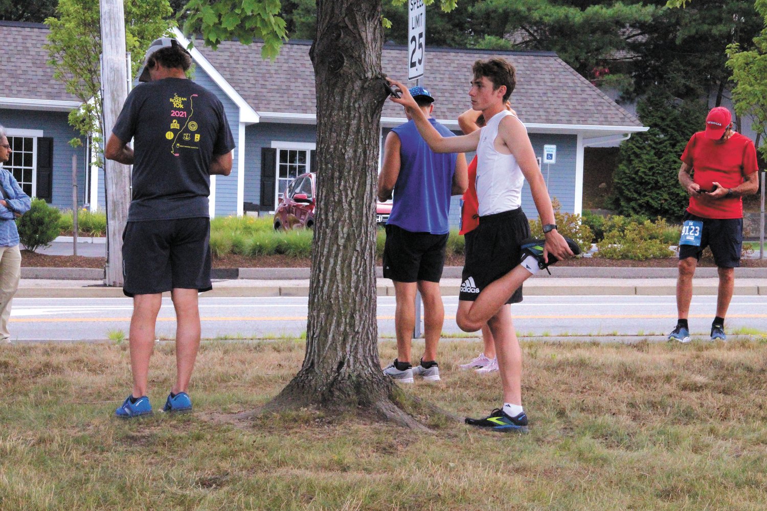 LIMBERING UP:  Pilgrim High School junior Jack Smith stretched in preparation of the 5K. He placed second with a time of 18:06.