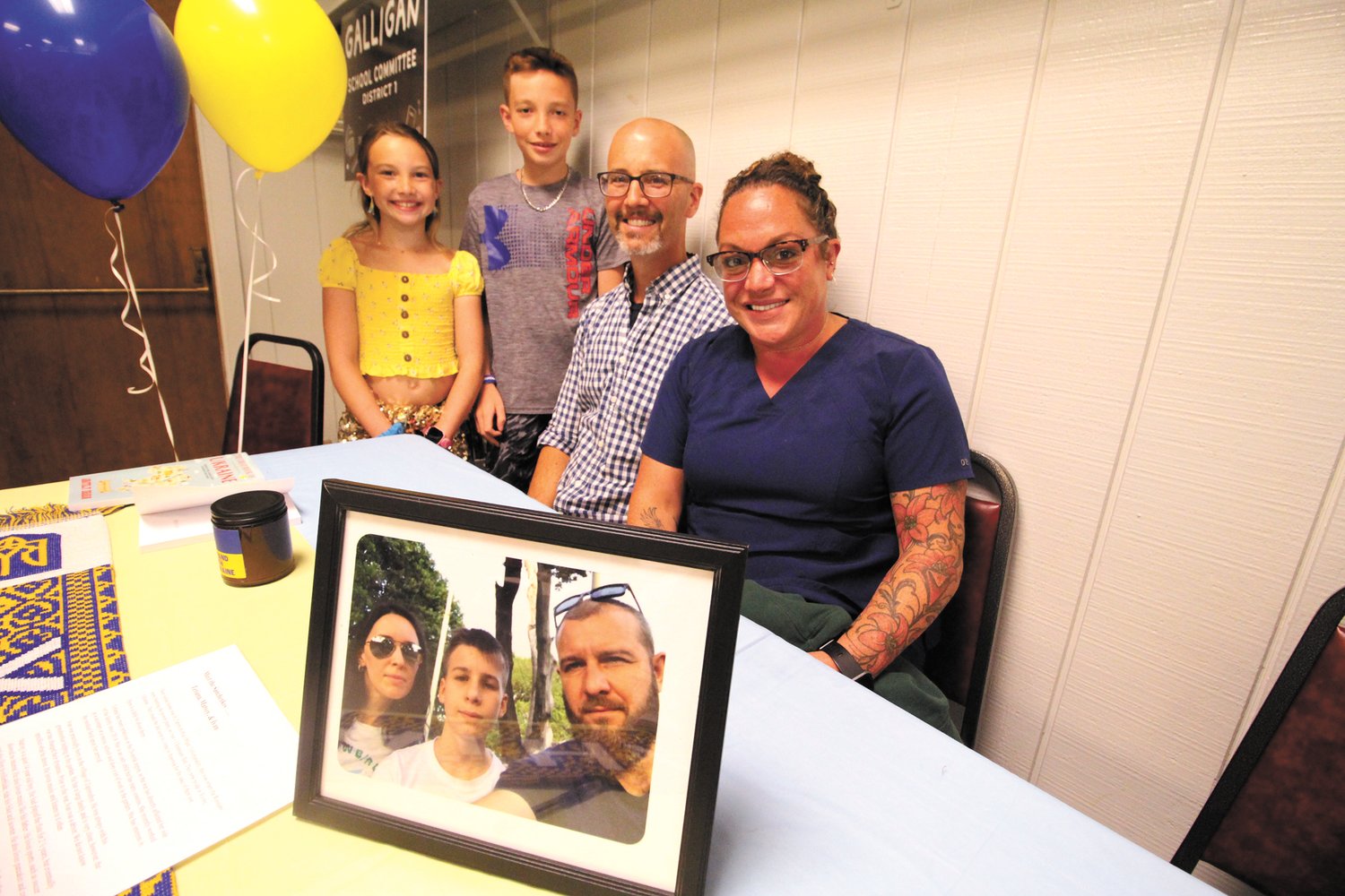 WARWICK COULD BE THEIR HOME: John, Stacey, Jacoby and Natalie Schmidt with a picture of the Sabchenko family, now living in Ukraine, who they will welcome into their Warwick home once cleared to come to this country. (Herald photo)