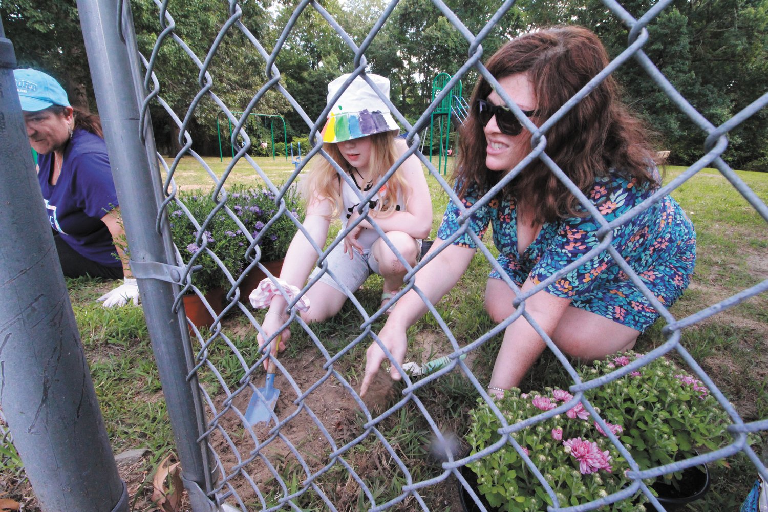 A GARDEN FOR NICOLE:  Kaley Miceli , who lives in the house where the Barrettes once lived and is a member of Girl Scout Troop 43  and Leah Charpentier Lavala plant a garden near the entrance to the park.
