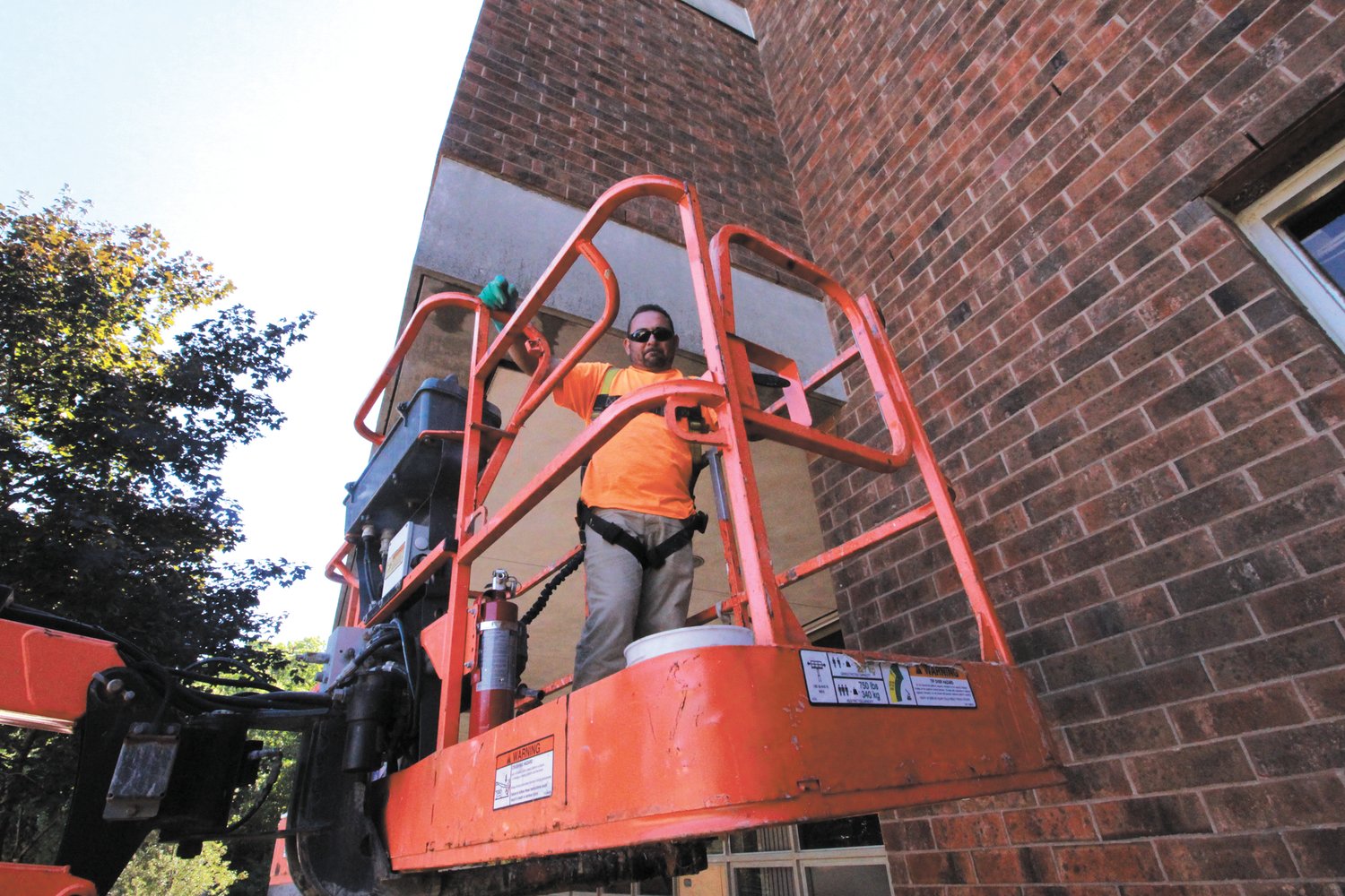 PATCH WORK: Kevin Arruda of Stevens Masonry works on patching up the exterior of the school.