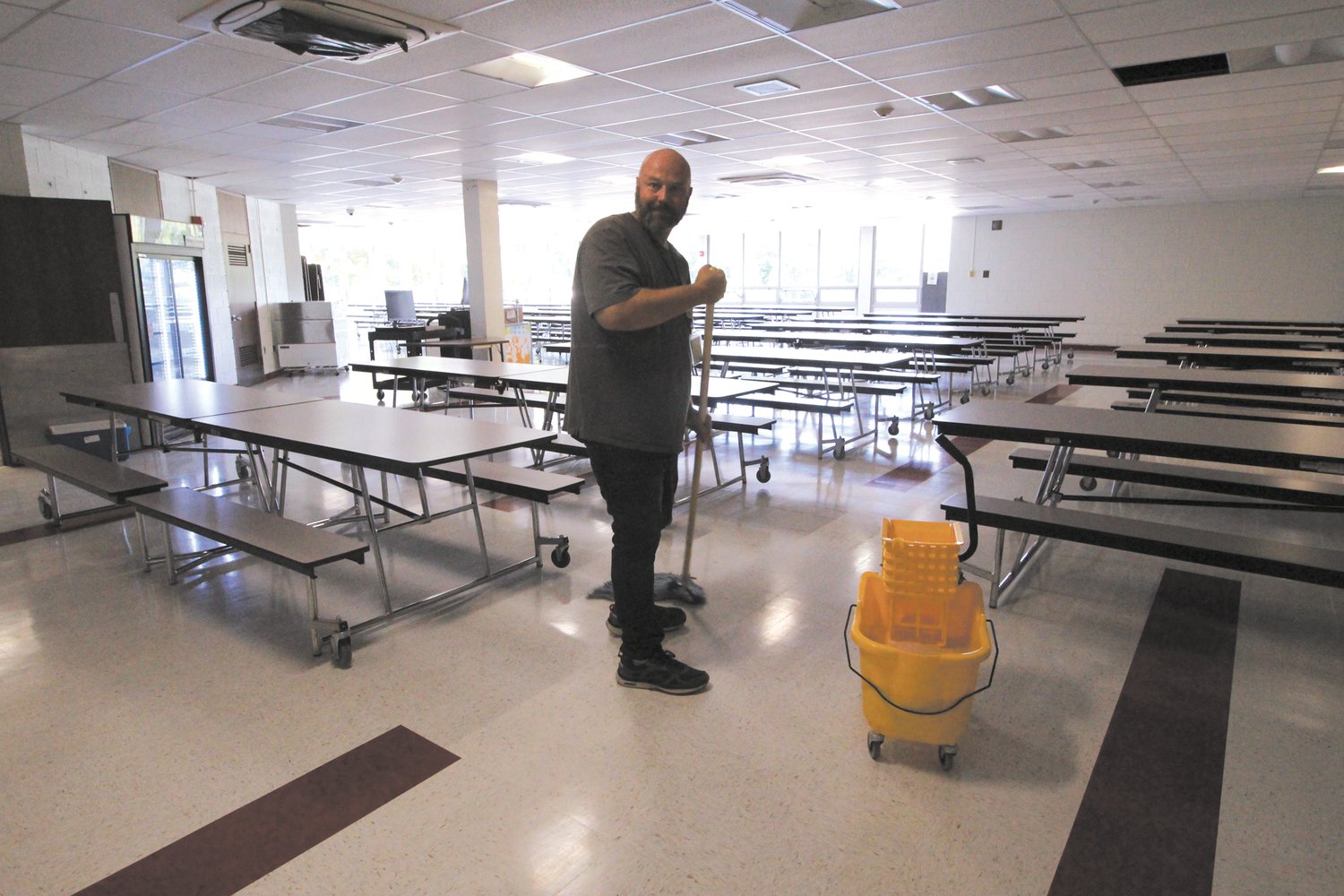 PUTTING ON THE SHINE: The Winman cafeteria, which has new flooring and lighting, gets a final cleaning.
