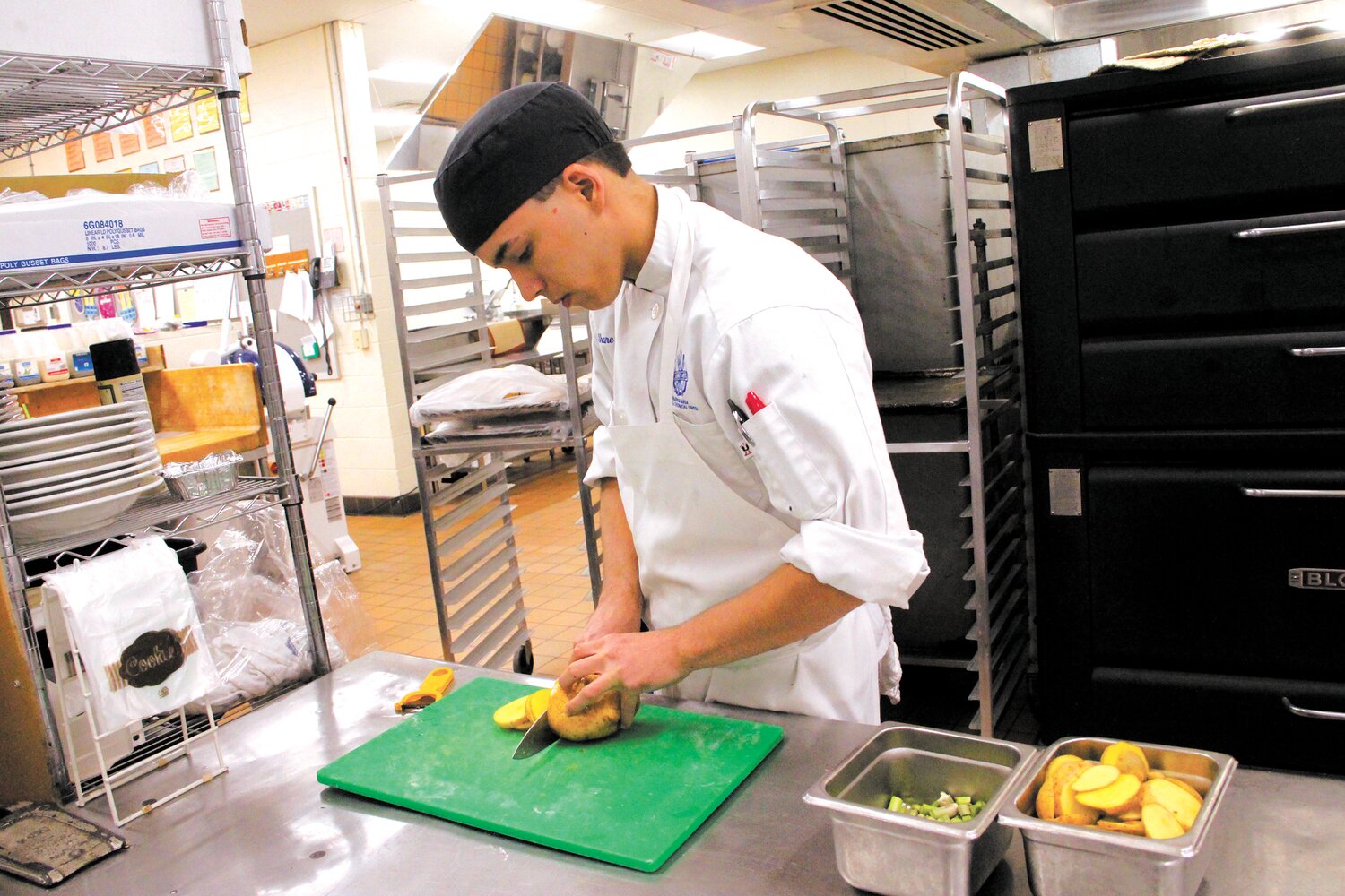 SLICED THIN: Warwick Area Career and Technology culinary student Shane Giroux cuts potatoes that were part of the school’s entry in the High School Seafood Cookoff held Thursday at the center. (Warwick Beacon Photos)