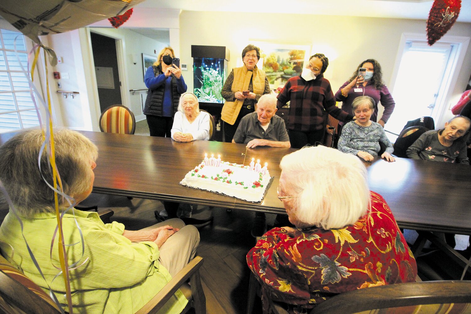 TIME FOR SOME SINGING: Residents, staff and family members of the Green House at Saint Elizabeth in East Greenwich celebrate the birthdays of Evaline and Annette.